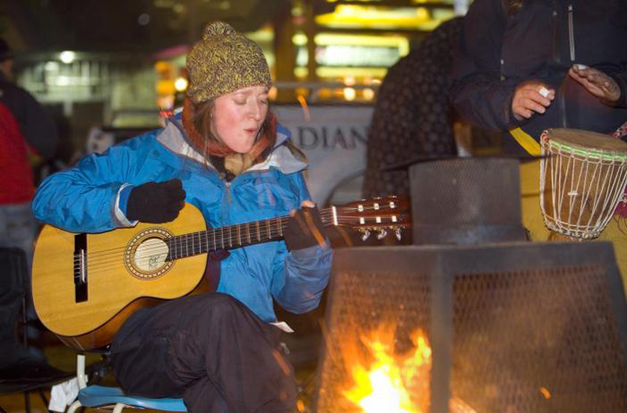 Girl playing Guitar by Fire