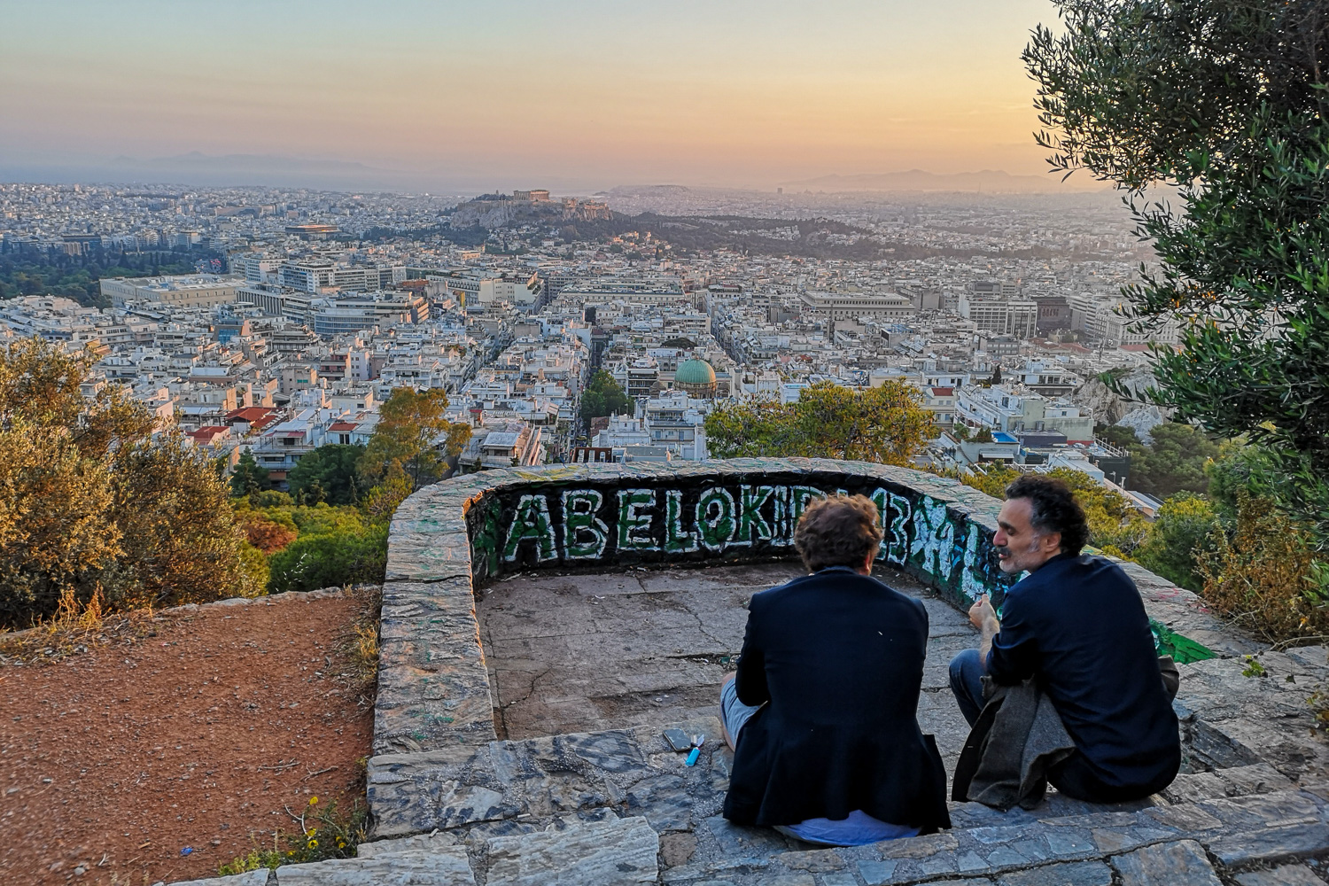 2 men enjoy a sunset on Lycabettus Hill in Athens, Greece