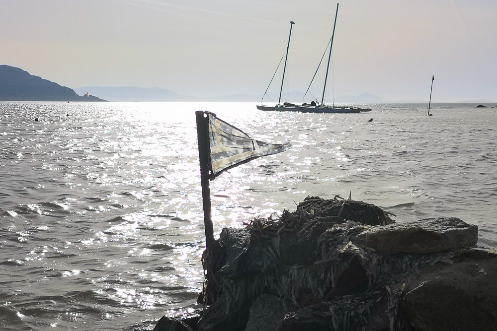 A Greece Flag with sailboats behind