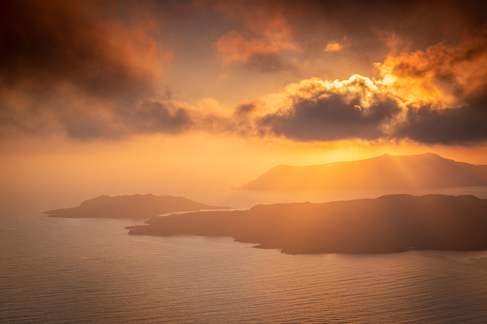 Light rays shine down at sunset in Santorini